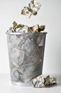 Throwing money away into trash can