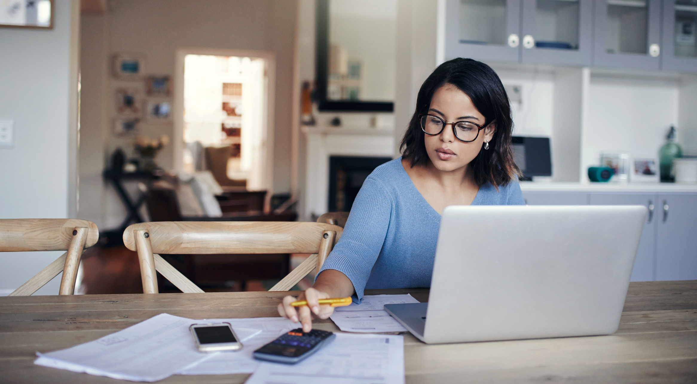 young woman using a laptop and calculator