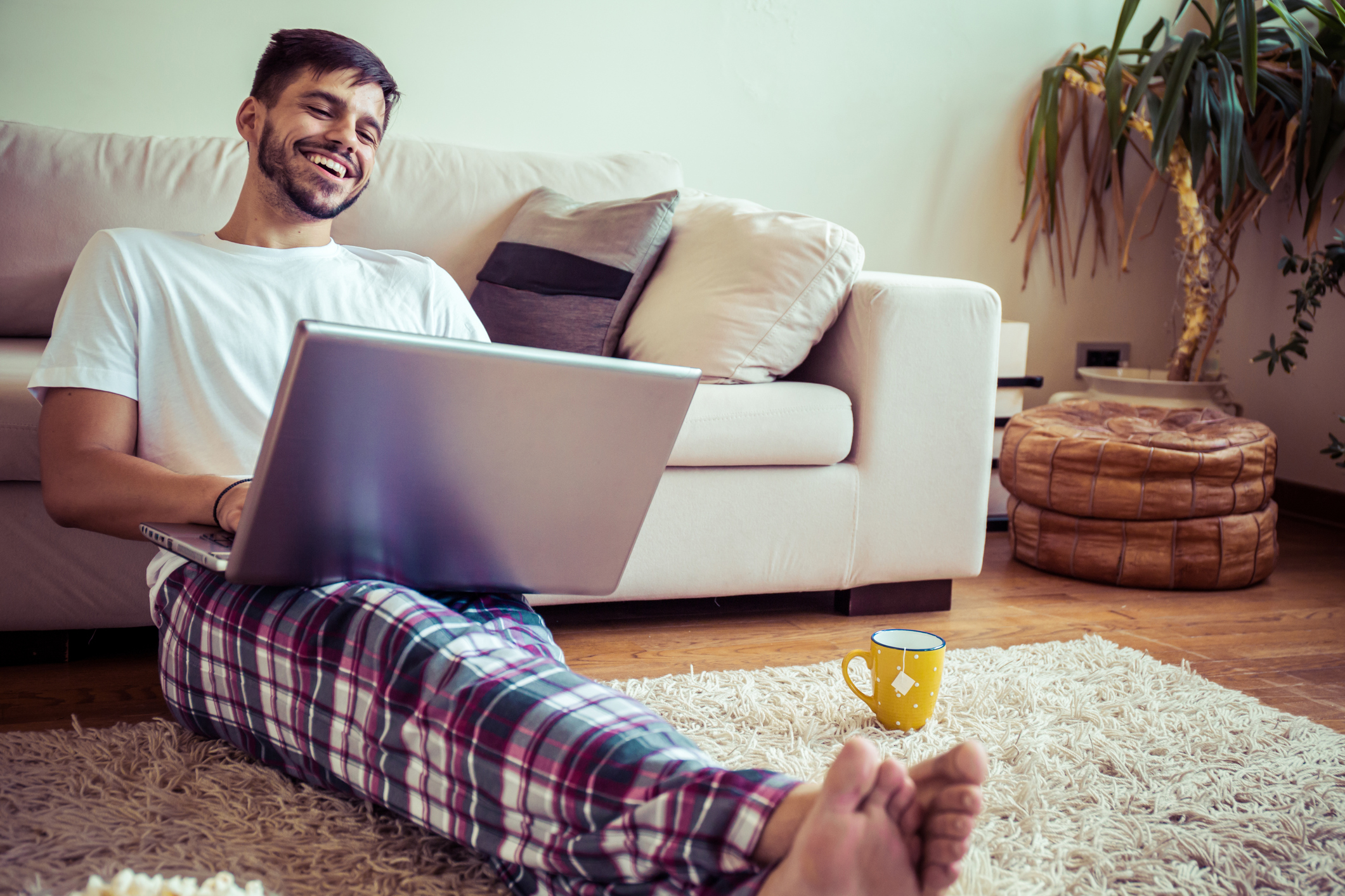 Man sitting in living room smiling at computer