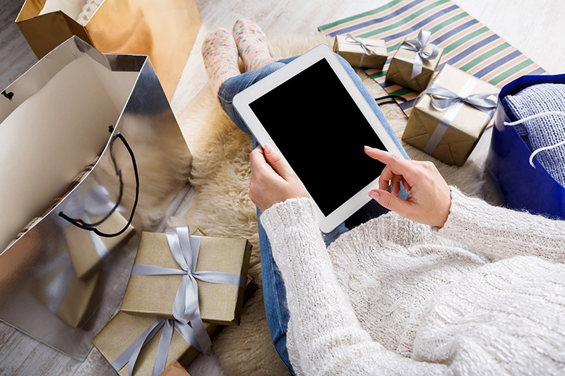 Young woman doing holiday shopping on tablet