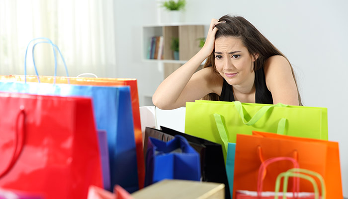 Mujer preocupada por deudas de adicta a las compras tras una juerga de compras