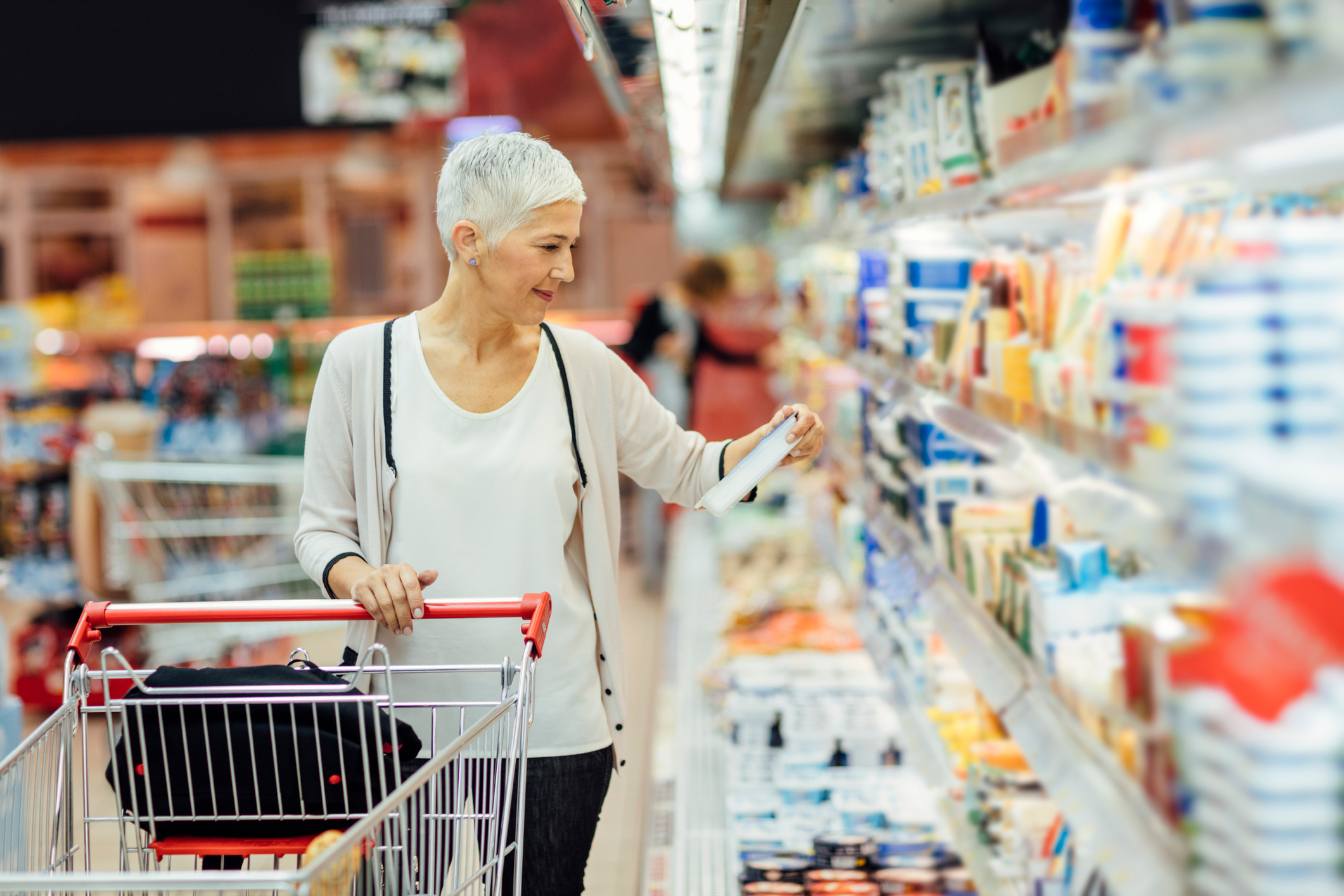 smiling woman shopping in local supermarket.