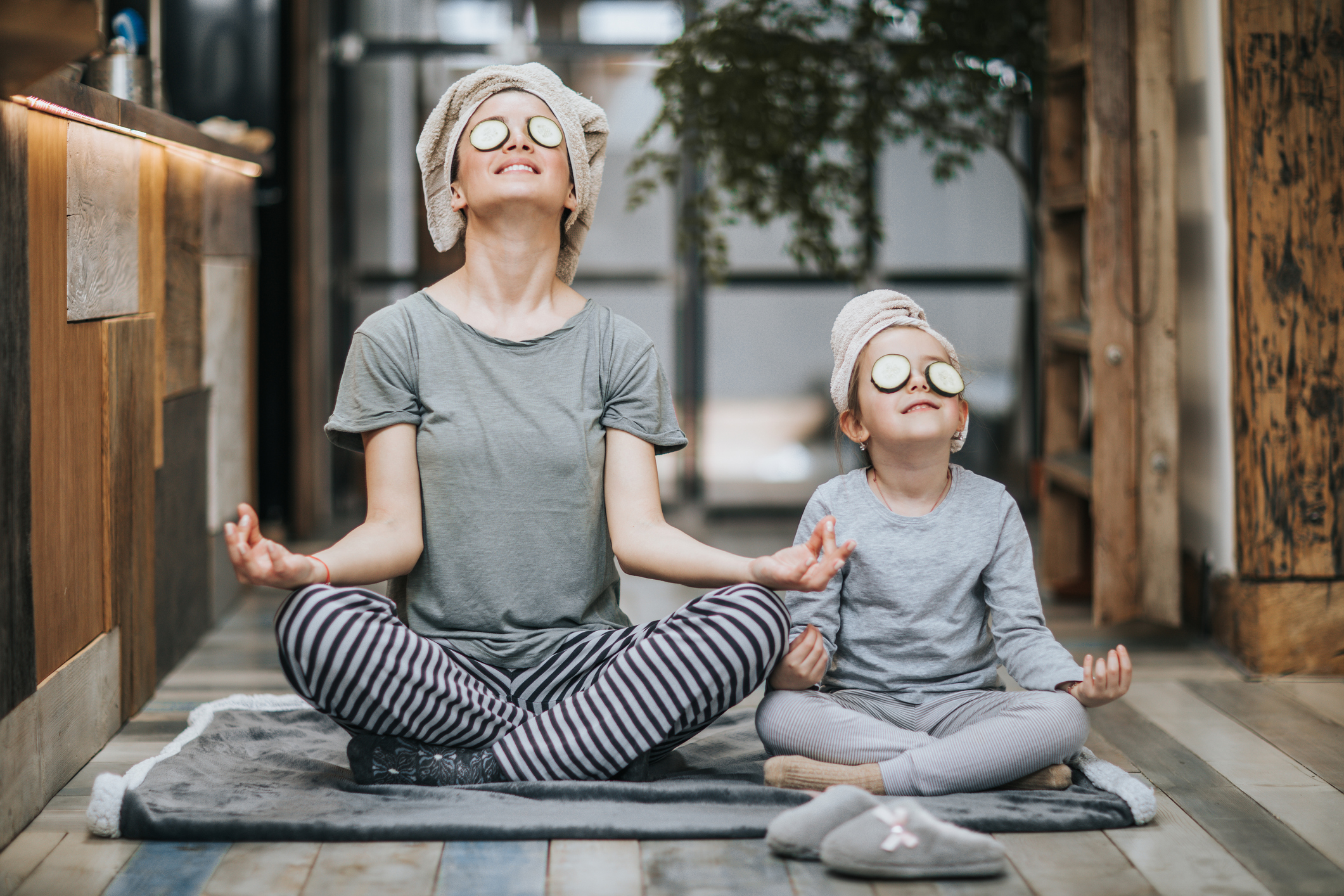 Relaxed mother and daughter exercising Yoga in the morning at home.