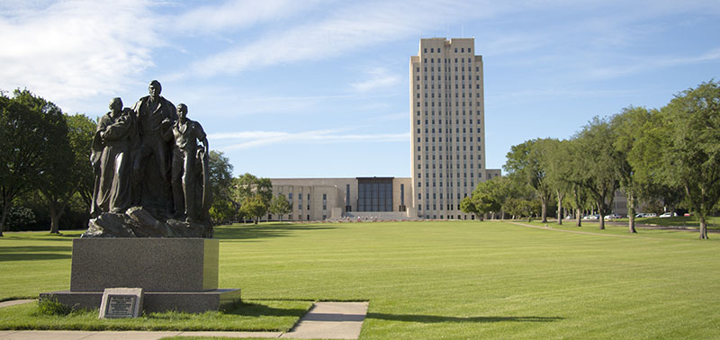 Estatuto de la Familia Pionera frente al edificio del capitolio del estado de Dakota del Norte en Bismarck